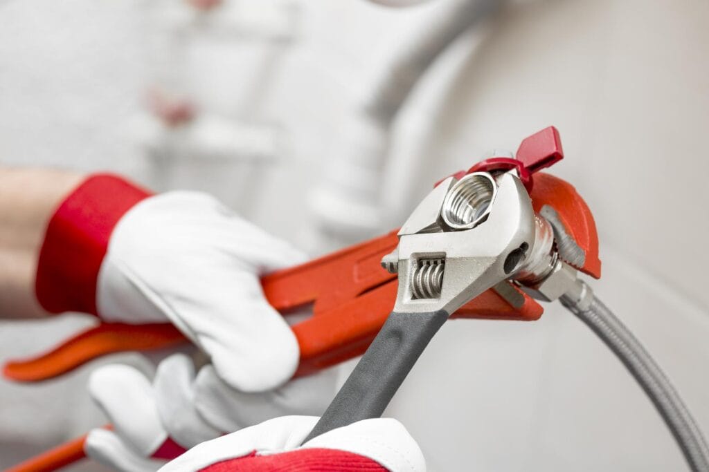 Plumber holding pipe wrenches for an emergency repair in Santa Cruz