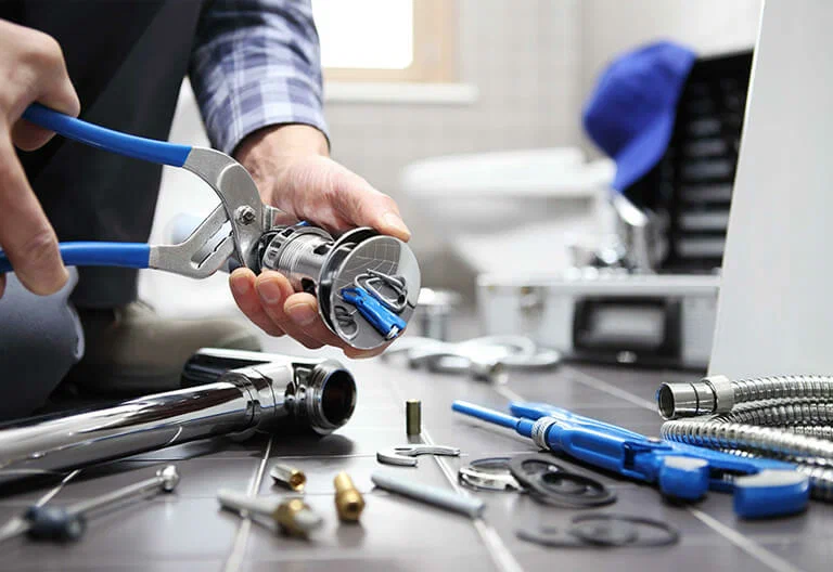 Technician repairing a plumbing fixture with professional tools in Santa Cruz