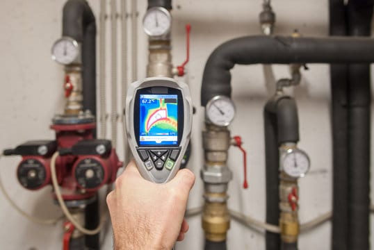 Plumber using a thermal imaging camera to inspect pipes in Santa Cruz