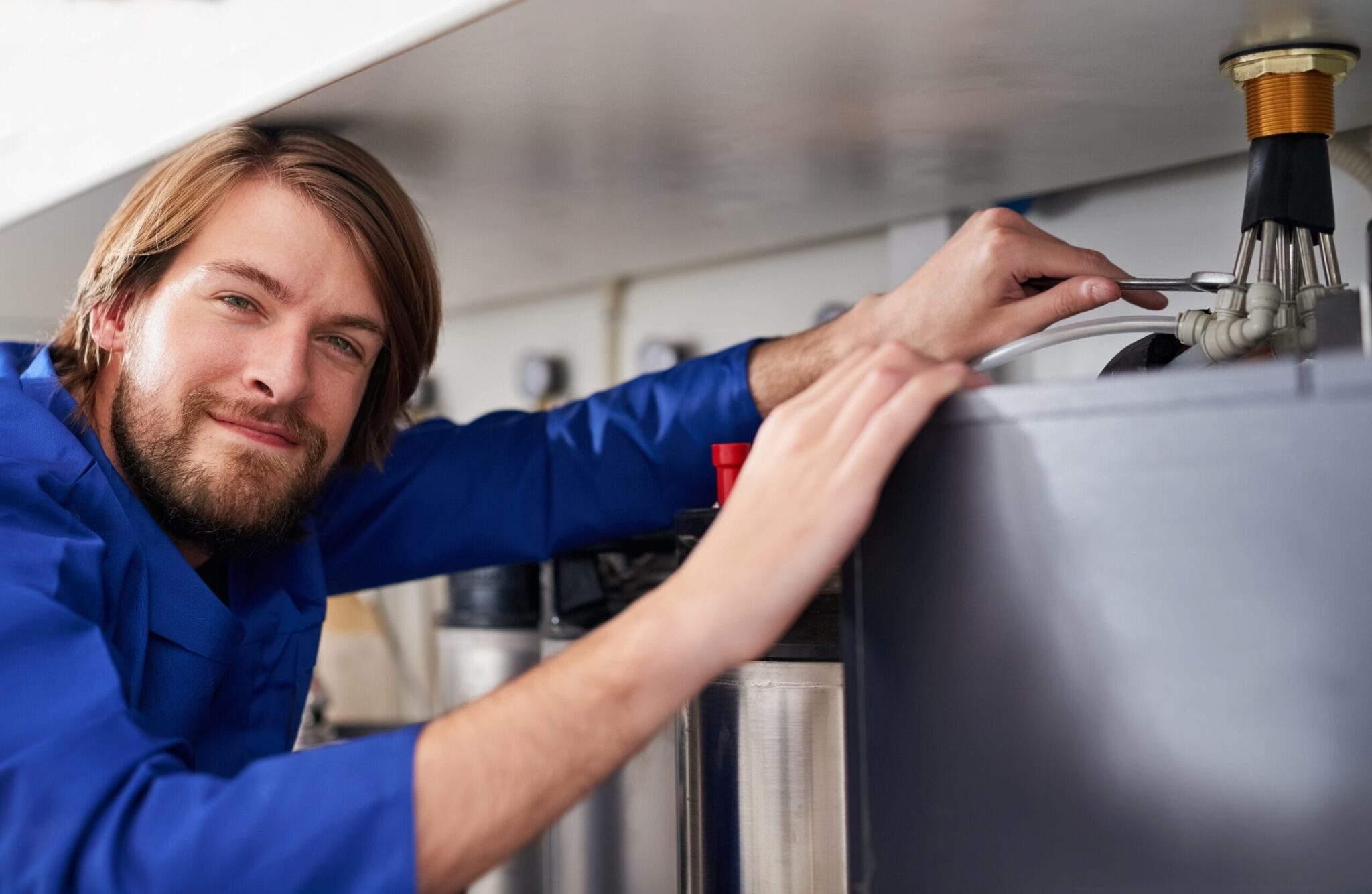 Technician servicing a residential water heater tank in Santa Cruz